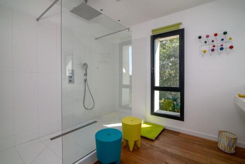 un bagno con doccia e due sgabelli colorati di Superbe villa contemporaine a Peymeinade