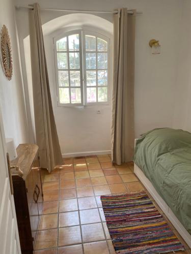 - une chambre avec un lit, une fenêtre et du carrelage dans l'établissement Rez-de-jardin villa provençale vue mer, à Marseille