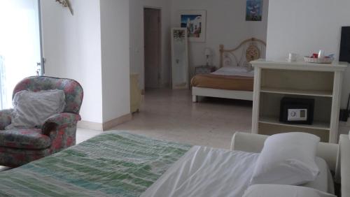 a room with a bed and a chair and a bedroom at Borgo Rosso di Sera - Resort Country Chic in San Lucido