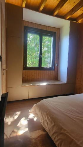 a bedroom with a bed and a window at Chalet Otsoak Chalet privé 3 chambres 6 personnes avec grande terrasse, garage couvert, vue montagnes à St Lary village in Saint-Lary-Soulan