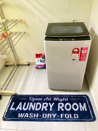 a laundry room trash bin on the floor with a sign at Homestay BAYT AL - JAZMY in Kuantan
