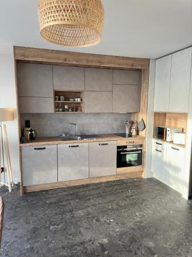 une cuisine avec des armoires blanches et un évier dans l'établissement Le plein ciel et mer, à Le Touquet-Paris-Plage