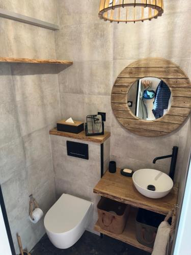 une salle de bain avec toilettes, lavabo et miroir dans l'établissement Le plein ciel et mer, à Le Touquet-Paris-Plage