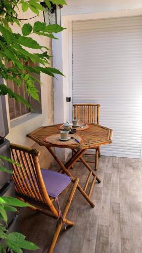 - une table et des chaises en bois dans l'établissement Clos Réginel Remparts Sud, à Avignon