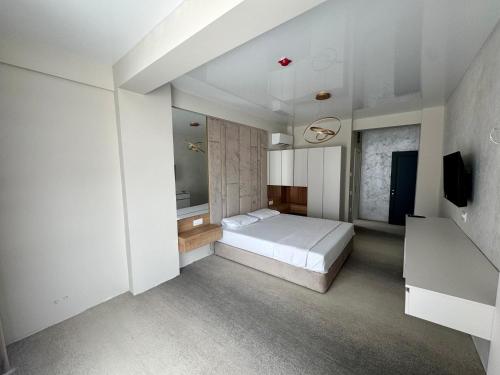 a white bedroom with a bed and a tv at Beach Vibe Hotel Mamaia Nord in Mamaia Nord