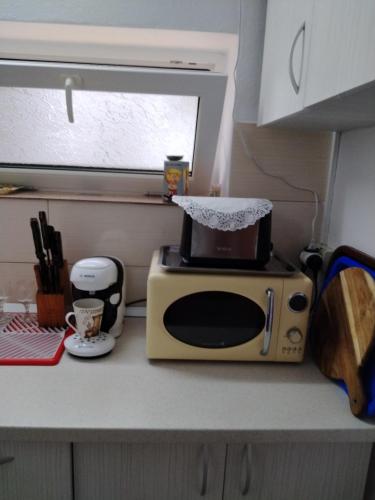 a microwave sitting on a kitchen counter with a coffee maker at Casa A&V in Vama Veche