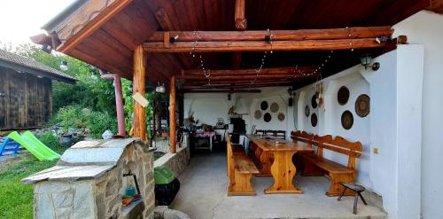 a patio with a wooden table and a bench at СПА къща за гости Каза Роза - Swiss Style Chalet Casa Rosa SPA Guest House in Kyustendil