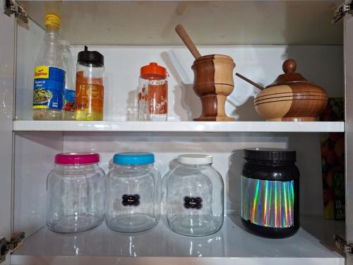 a refrigerator filled with lots of glass jars at Apê confortável, com Alexa. Ótima localização in Ilhéus