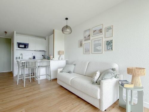 un salon avec un canapé blanc et une cuisine dans l'établissement Sol-y-Days Escale Studio face Mer, à La Grande Motte