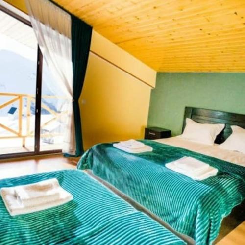 a bedroom with two beds with towels on them at Sunny Hill Gudauri in Gudauri