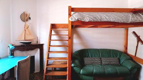 - une chambre avec des lits superposés et un canapé vert dans l'établissement Clos Réginel Remparts Sud, à Avignon