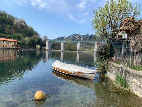 a boat sitting in the water near a bridge at La casetta di Sonia in Sarnico