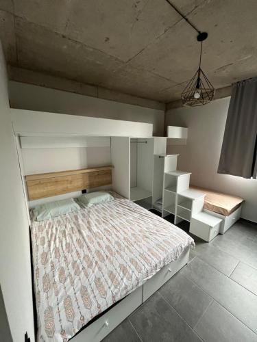 a bedroom with a large bed and shelves at Kaprovani terrace in Ozurgetʼi