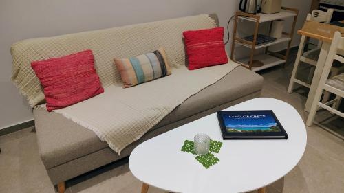 a living room with a couch with pillows and a table at Kleopatra's residence in Bendevís