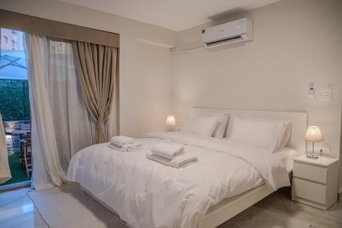 a bedroom with a white bed with towels on it at Modern 2BR - Private Garden Nook in Cairo