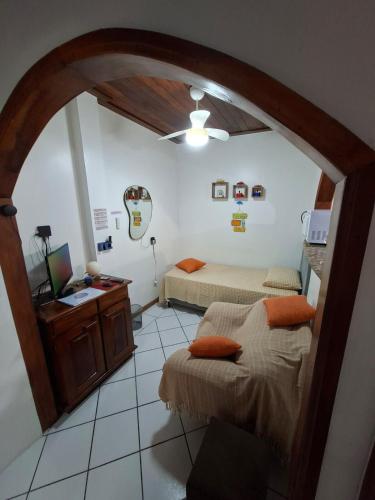 a room with two beds and a desk in it at Apê confortável, com Alexa. Ótima localização in Ilhéus