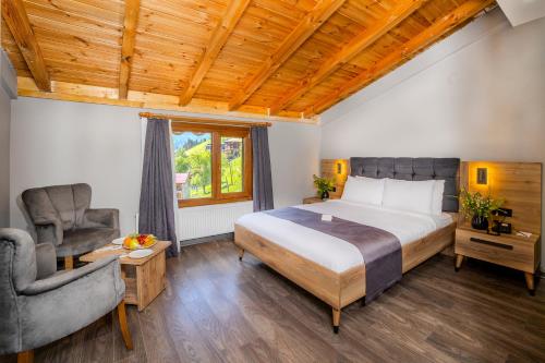 a bedroom with a large bed and a chair at Ayder Palazzo Hotel in Ayder Yaylasi