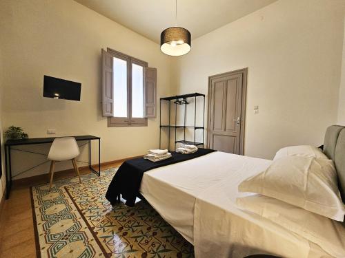 a bedroom with a bed and a desk and a window at Fardella Hospitality in Trapani