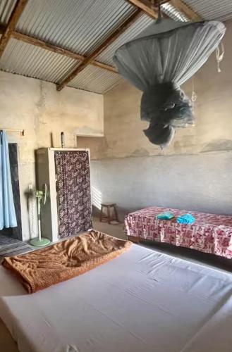 a bedroom with two beds and a ceiling at Jamebougoum in Mar Lodj
