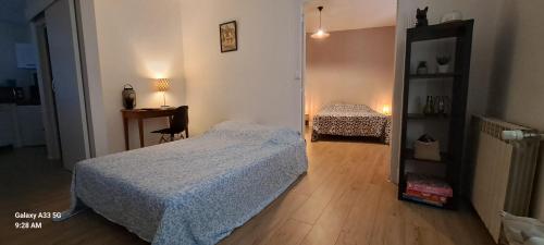 a bedroom with a bed and a desk and a mirror at Appartement confort deux Etoiles in Dole