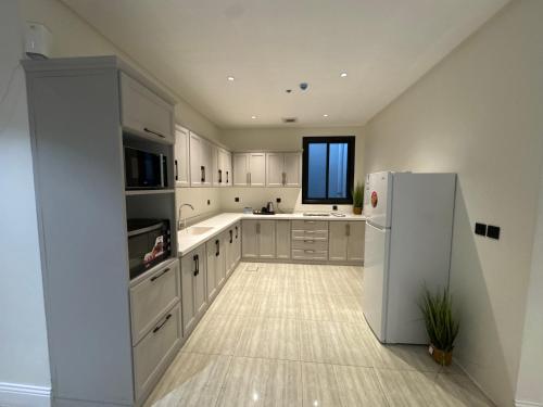 una cucina con mobili bianchi e un frigorifero bianco di روح ريزدنس Rawh Residence a Riyad