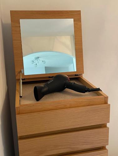 a black umbrella is sitting in a wooden drawer at Beautiful Peaceful Studio Flat in Waltham Abbey