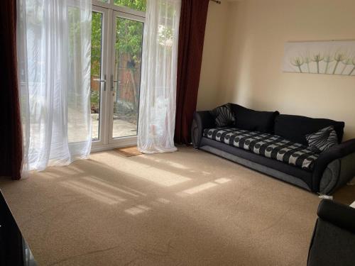a living room with a couch in front of a window at Langham Lake House in Simpson