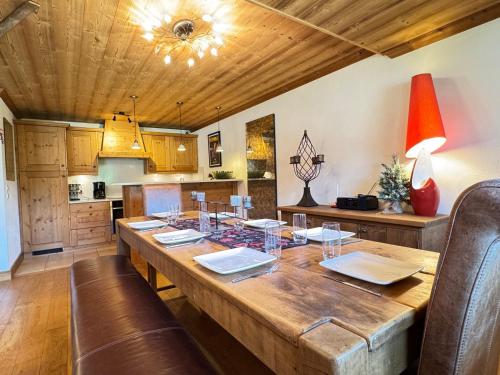 une salle à manger avec une table en bois et une cuisine dans l'établissement Appartement 3 chambres avec balcon, proche des pistes, parking, WiFi, TV avec Netflix et Amazon. - FR-1-623-79, aux Gets