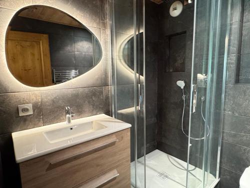 une salle de bain avec un lavabo et une douche avec un miroir dans l'établissement Appartement 3 chambres avec balcon, proche des pistes, parking, WiFi, TV avec Netflix et Amazon. - FR-1-623-79, aux Gets