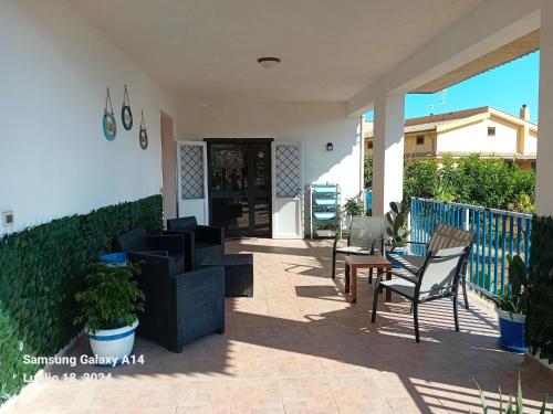 un patio di una casa con sedie e tavoli di La Cycas a Trabia