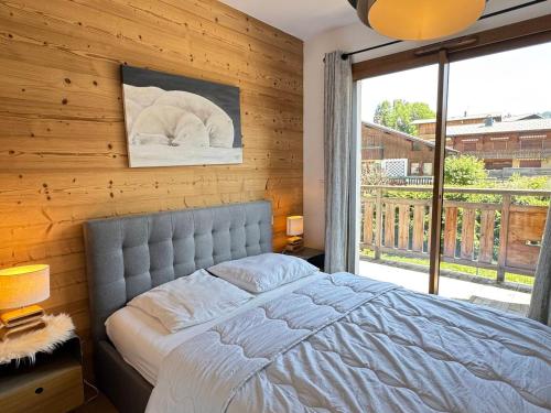 une chambre avec un lit et une grande fenêtre dans l'établissement Magnifique Appartement 4* Les Gets, 48m², Proche Centre, Balcons, 6 Couchages, Services Inclus - FR-1-623-20, aux Gets