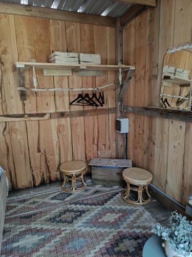 a room with two chairs and a table and shelves at cabane ô domaine södjé in Saint-Yrieix-sous-Aixe