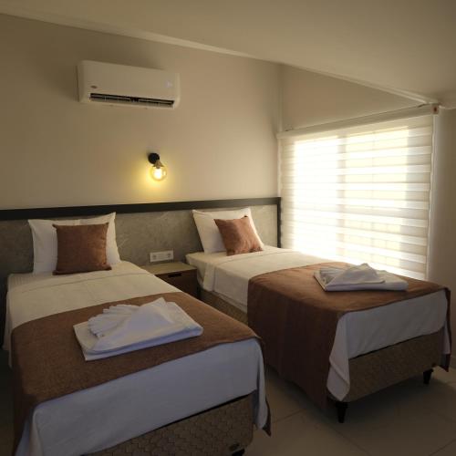 a hotel room with two beds and a window at Yaz Villa in Fethiye