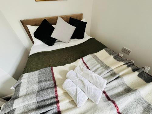 a bed with a blanket and pillows on it at Town centre with parking in Huntingdon