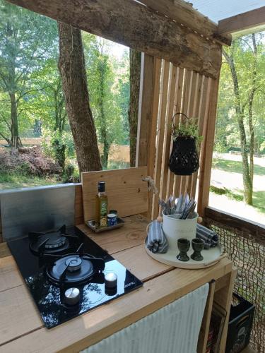 a stove top sitting on a table in a porch at cabane ô domaine södjé in Saint-Yrieix-sous-Aixe