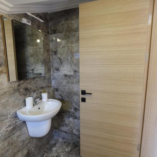 a bathroom with a sink and a wooden door at Yaz Villa in Fethiye