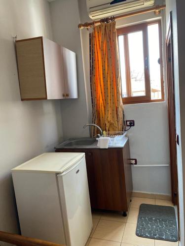 a small kitchen with a sink and a window at Begaj Rooms in Durrës