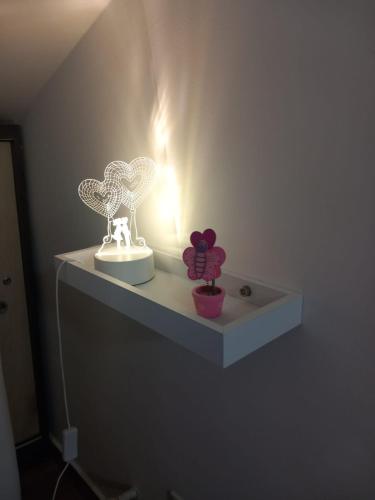 a white shelf with two birds on a wall at Casa Rosy Sicilia in Brolo