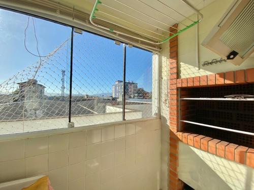a kitchen with a window with a view of the city at apt 2 dorm capão da canoa in Capão da Canoa