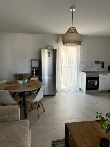 une cuisine avec une table et un réfrigérateur en acier inoxydable dans l'établissement T3 Centre ville, à Ajaccio