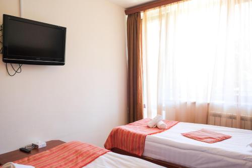 a bedroom with two beds and a flat screen tv at Ani Resort in Artavaz