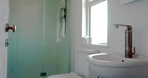 a bathroom with a sink and a toilet and a shower at The Loriston in Eastbourne