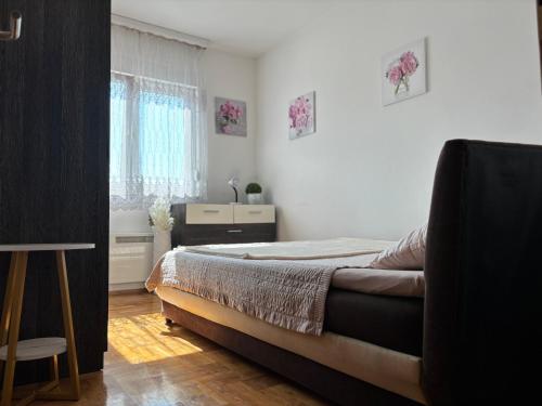 a bedroom with a bed and a desk and a window at Cozy corner Mostar in Mostar