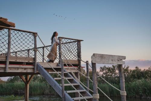 a woman walking down a wooden bridge at Mas De Calabrun in Saintes-Maries-de-la-Mer
