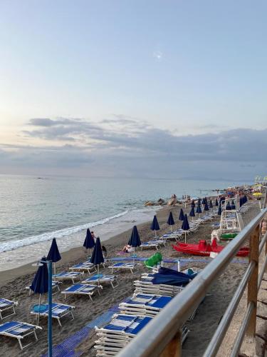 a beach with chairs and umbrellas and the ocean at Casa Rosy Sicilia in Brolo