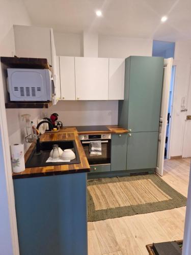 une cuisine avec un évier et un micro-ondes dans l'établissement Apartment - 1min to train station - 13min to Paris, à Maisons-Laffitte