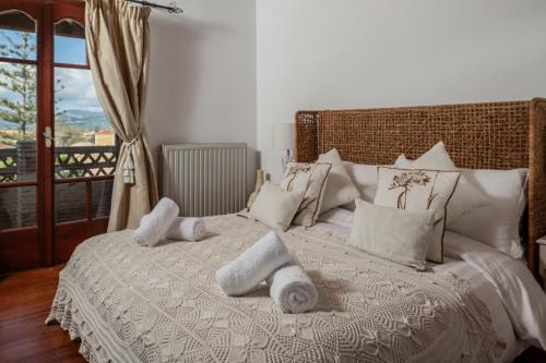 a bedroom with a white bed with towels on it at Garden Village Residence in Kalamaki