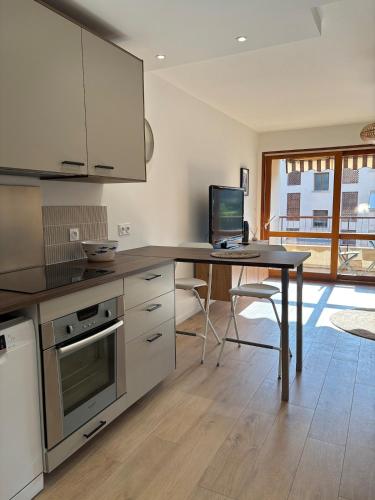 - une cuisine avec une table et un ordinateur dans l'établissement Grand Studio Cozy, 650m de la plage et 200m du tennis club, à Six-Fours-les-Plages