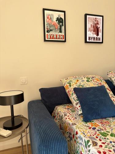 - un salon avec un canapé et deux photos sur le mur dans l'établissement Grand Studio Cozy, 650m de la plage et 200m du tennis club, à Six-Fours-les-Plages