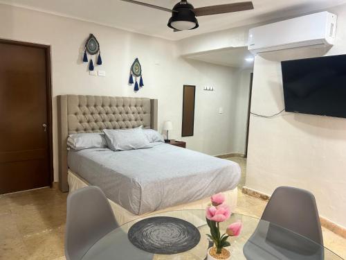 a bedroom with a bed and a flat screen tv at blue angel 6 a pasos de la playa in Playa del Carmen